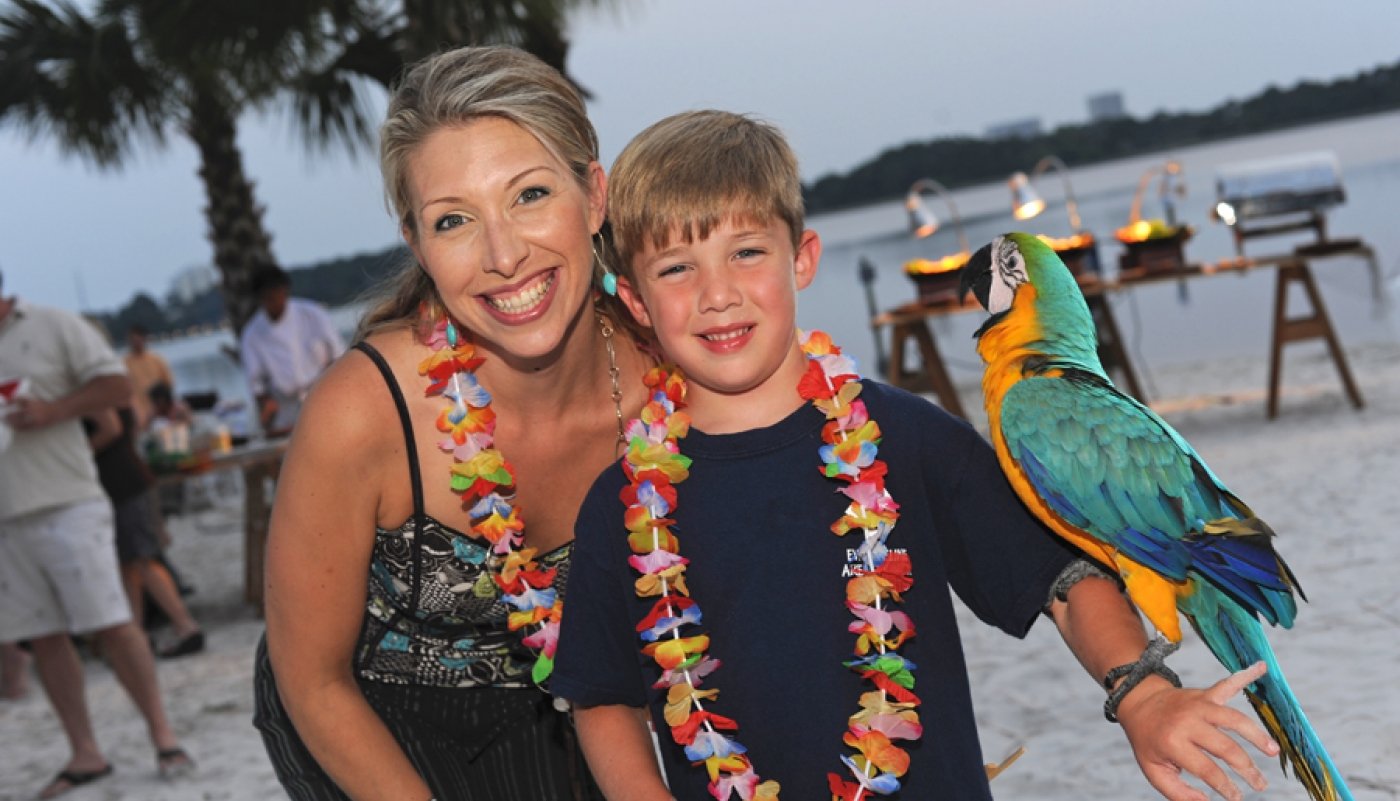 Mother and son posing with a parrot