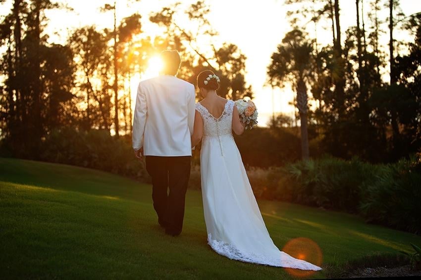 bride and groom walking into the sunset