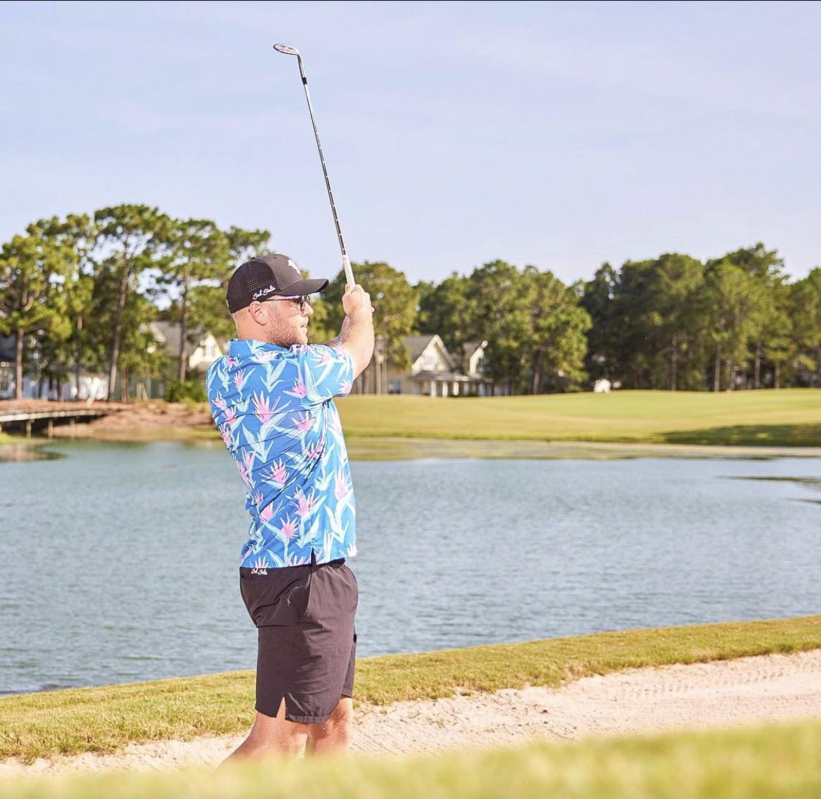 Man swinging his golf club on the fairway. 