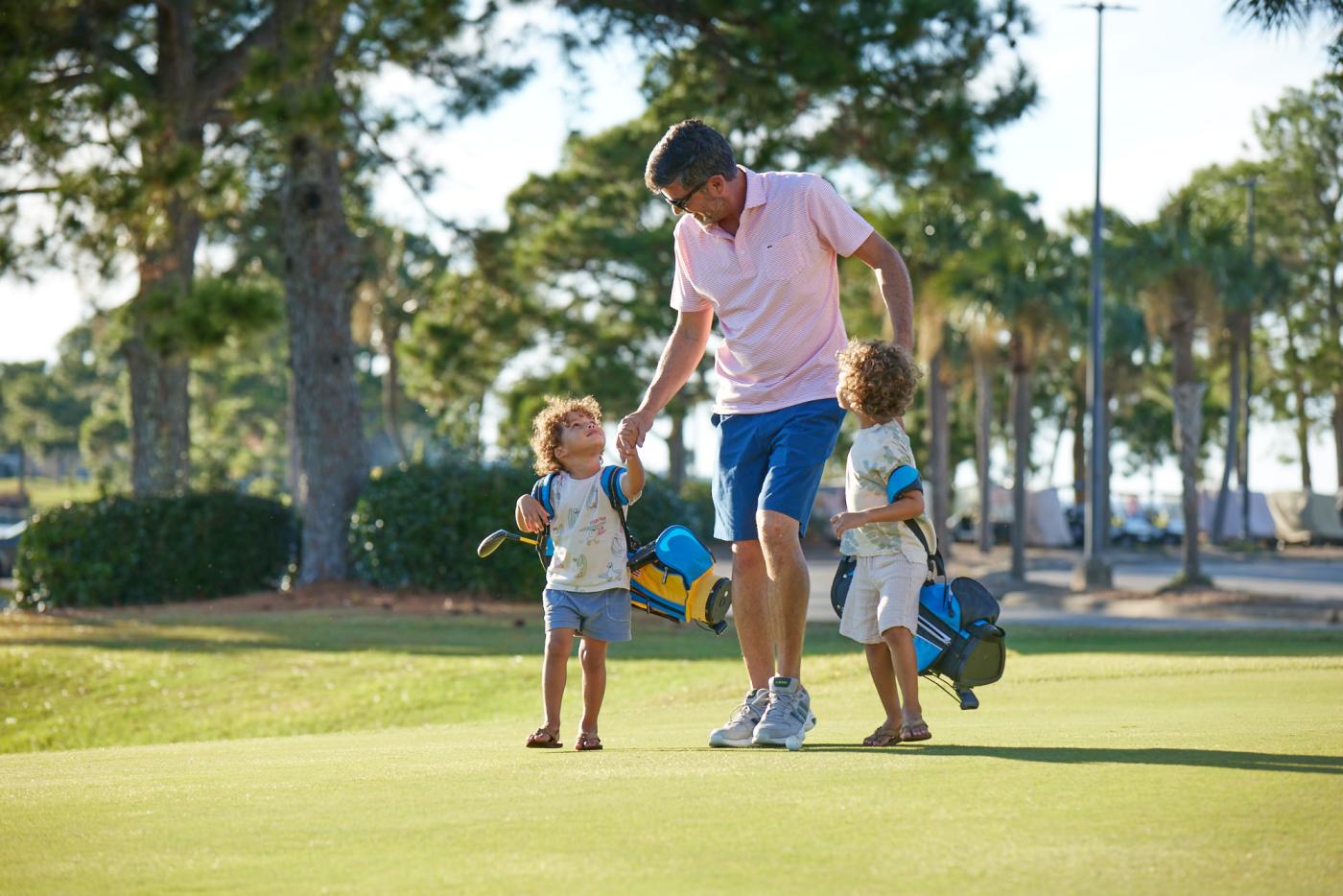 Father golfing with children. 