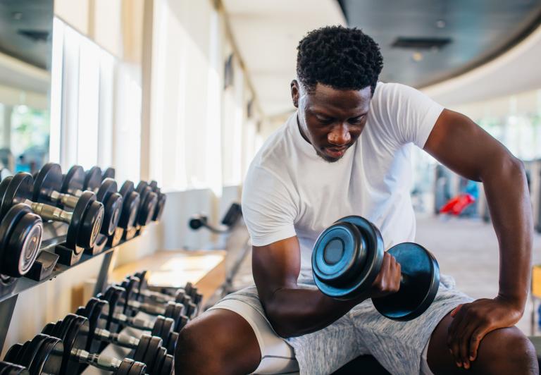 man sitting with a hand weight doing a bicep curl