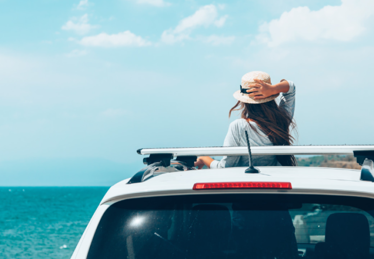 Woman in a car by the beach.